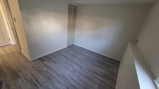 unfurnished bedroom with a closet, baseboards, and wood finished floors