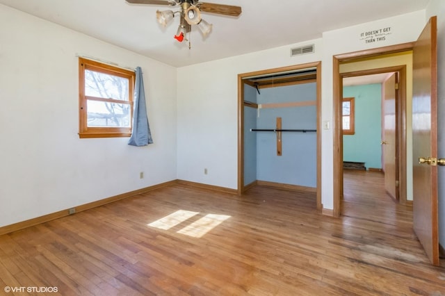 unfurnished bedroom featuring baseboards, visible vents, light wood-style flooring, ceiling fan, and a closet