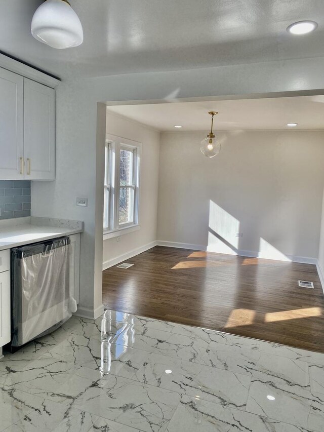 8416 S Bennett Ave, Chicago, IL 60617 - kitchen featuring baseboards, light countertops, white cabinets, stainless steel dishwasher, and backsplash