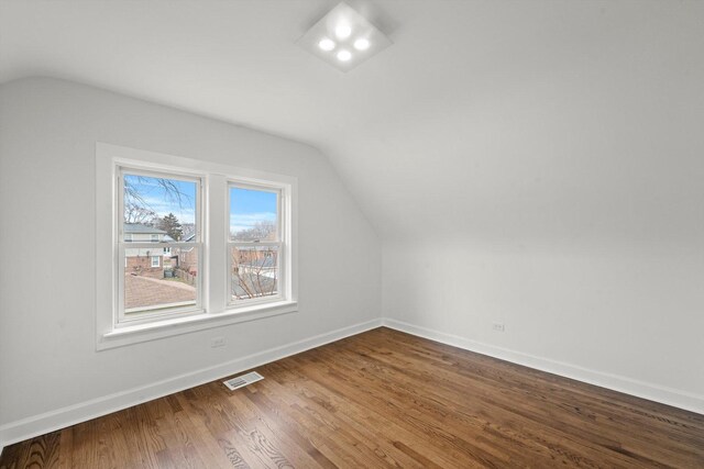 8416 S Bennett Ave, Chicago, IL 60617 - bonus room featuring visible vents, dark wood-type flooring, baseboards, and vaulted ceiling