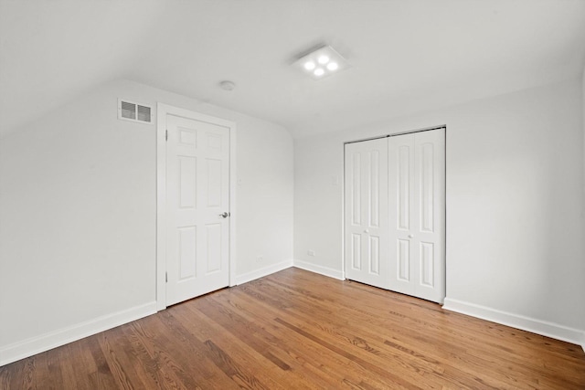 8416 S Bennett Ave, Chicago, IL 60617 - unfurnished bedroom with lofted ceiling, wood finished floors, visible vents, and baseboards