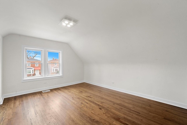 8416 S Bennett Ave, Chicago, IL 60617 - additional living space with visible vents, baseboards, lofted ceiling, and wood finished floors