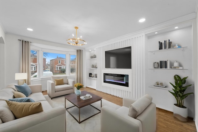 8416 S Bennett Ave, Chicago, IL 60617 - living area with built in shelves, wood finished floors, a glass covered fireplace, crown molding, and a chandelier