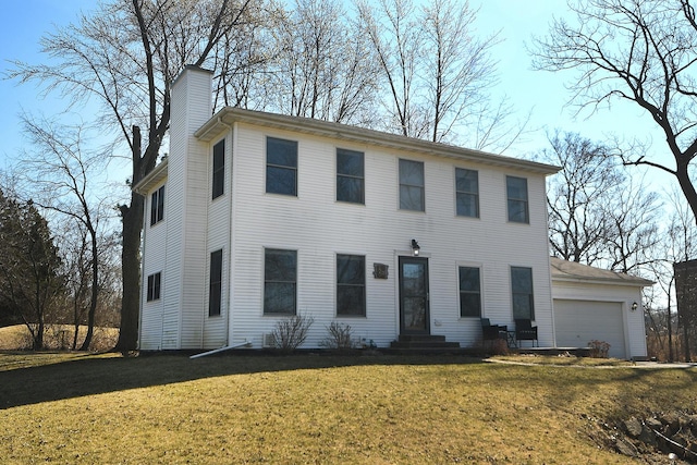 colonial-style house featuring entry steps, a chimney, and a front yard