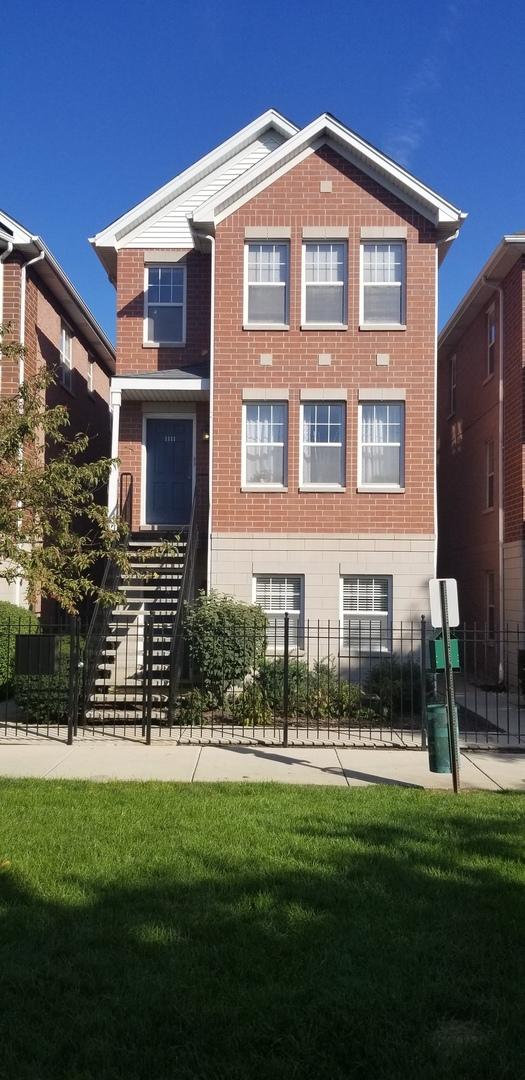 exterior space with brick siding, stairway, a front yard, and fence