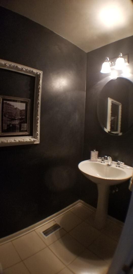 bathroom with tile patterned floors, baseboards, visible vents, and a sink