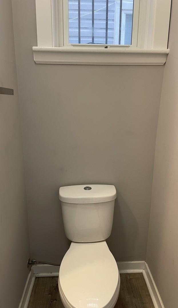 bathroom featuring baseboards, toilet, and wood finished floors