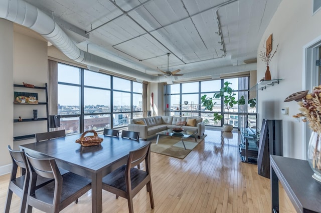 dining area featuring a wall of windows, light wood-type flooring, visible vents, and rail lighting