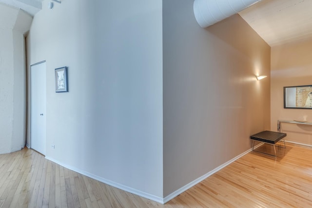 corridor featuring baseboards and wood finished floors