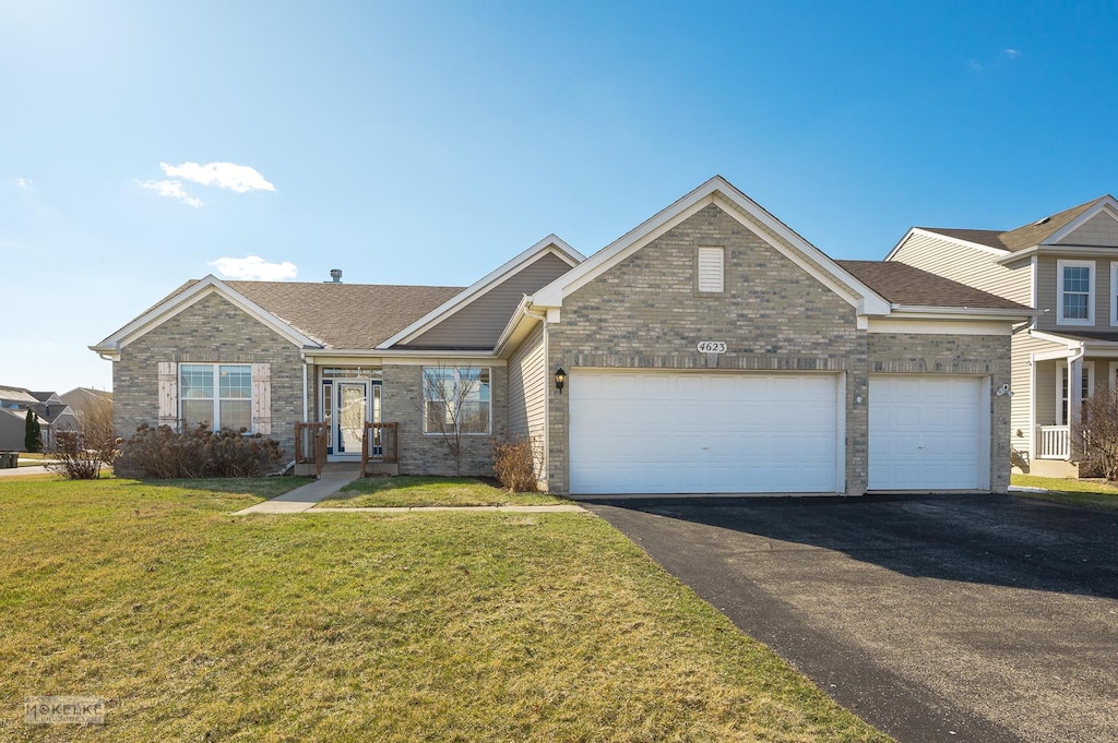 view of front of home featuring driveway, a shingled roof, a front yard, an attached garage, and brick siding