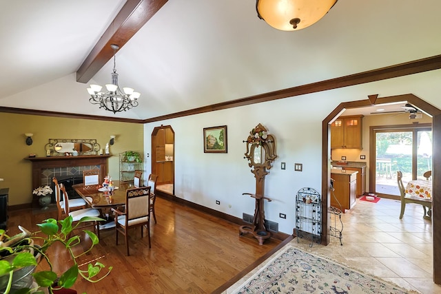 dining space featuring baseboards, lofted ceiling with beams, arched walkways, ornamental molding, and light wood-type flooring