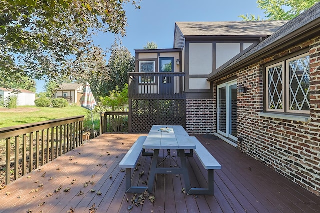 wooden deck featuring outdoor dining area and a yard