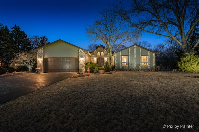 view of front facade featuring brick siding, driveway, a front lawn, and a garage