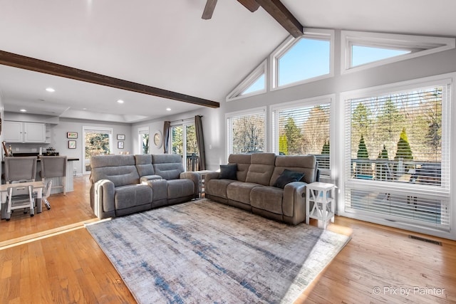 living room featuring visible vents, beam ceiling, high vaulted ceiling, light wood finished floors, and ceiling fan