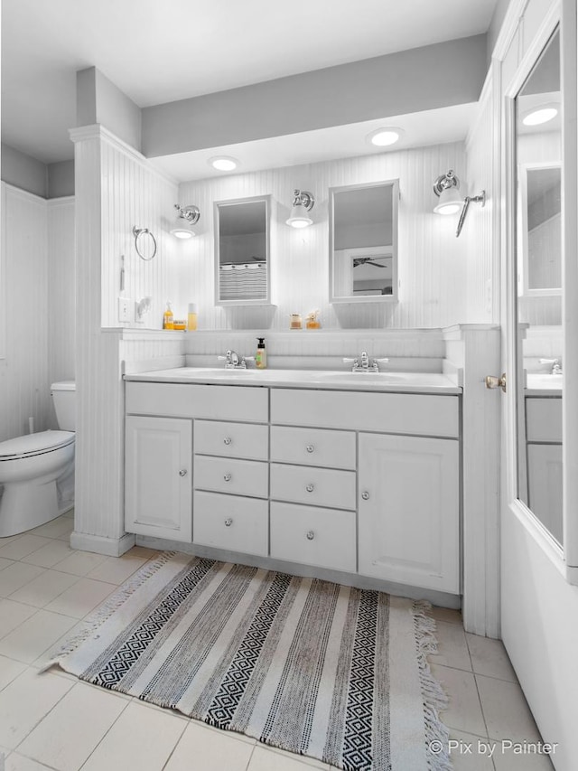 full bathroom featuring tile patterned flooring, double vanity, toilet, and a sink