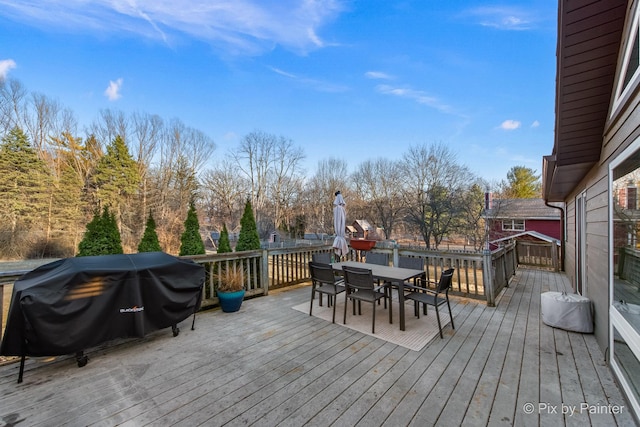 wooden terrace with area for grilling and outdoor dining area