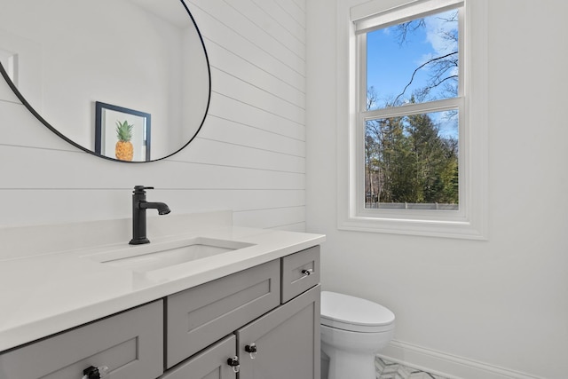 bathroom with baseboards, toilet, and vanity