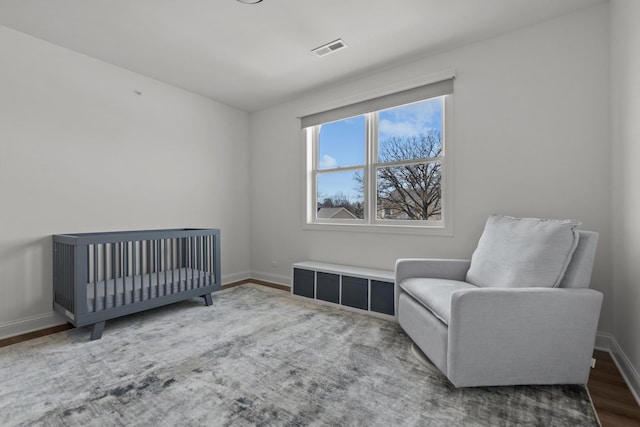 bedroom featuring wood finished floors, baseboards, and visible vents