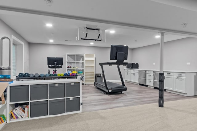 exercise room with light wood finished floors and recessed lighting