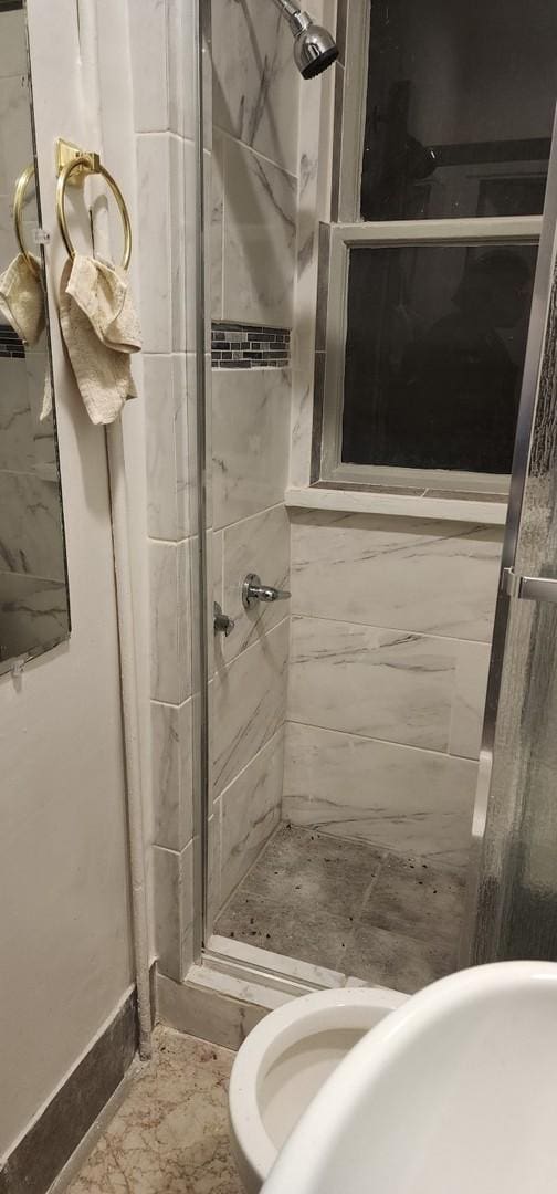 bathroom with baseboards and a stall shower