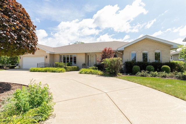 ranch-style home with concrete driveway, an attached garage, and brick siding