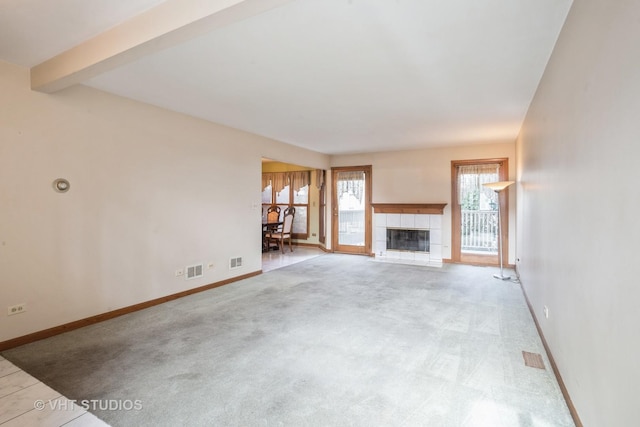 unfurnished living room featuring a fireplace, baseboards, carpet floors, and beamed ceiling