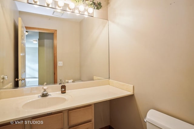 half bathroom featuring toilet and vanity