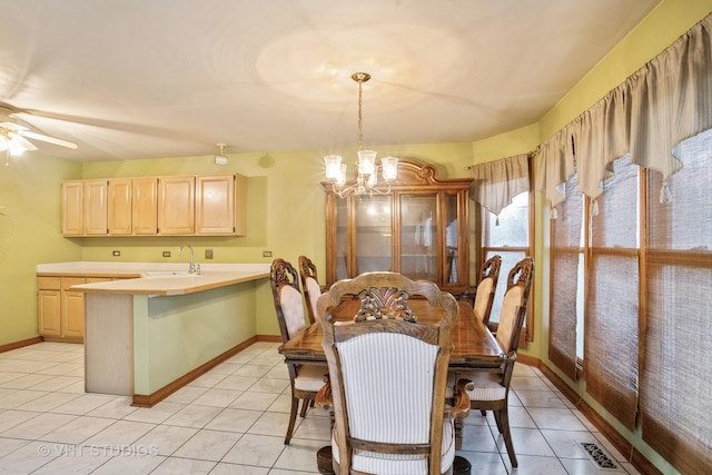 dining room with a chandelier, light tile patterned floors, baseboards, and a ceiling fan