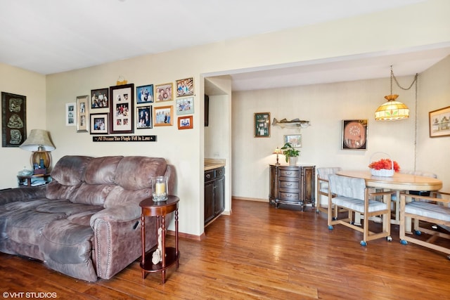 living area with baseboards and wood finished floors