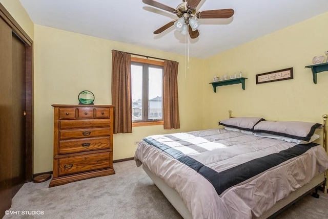 carpeted bedroom with a closet, a ceiling fan, and baseboards