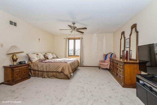 bedroom featuring visible vents, baseboards, light colored carpet, and a ceiling fan