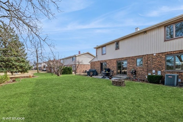 back of house featuring cooling unit, a patio, a lawn, and brick siding