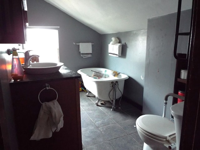 410 S Franklin Ave, Polo, IL 61064 - bathroom with a freestanding bath, toilet, vanity, tile patterned floors, and lofted ceiling