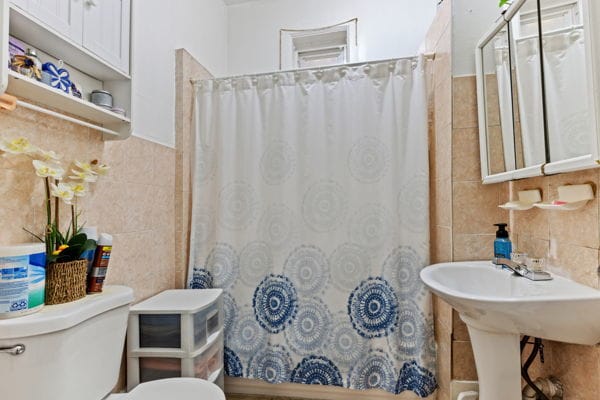 2020 W Superior St, Chicago, IL 60612 - bathroom featuring a shower with curtain, toilet, and tile walls