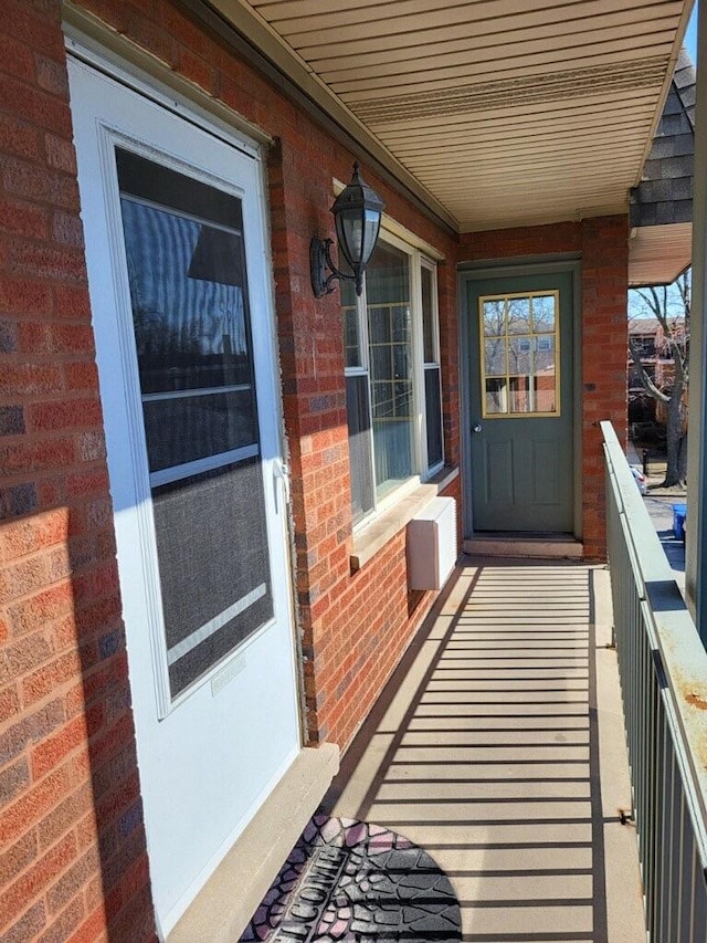 doorway to property with brick siding and a balcony