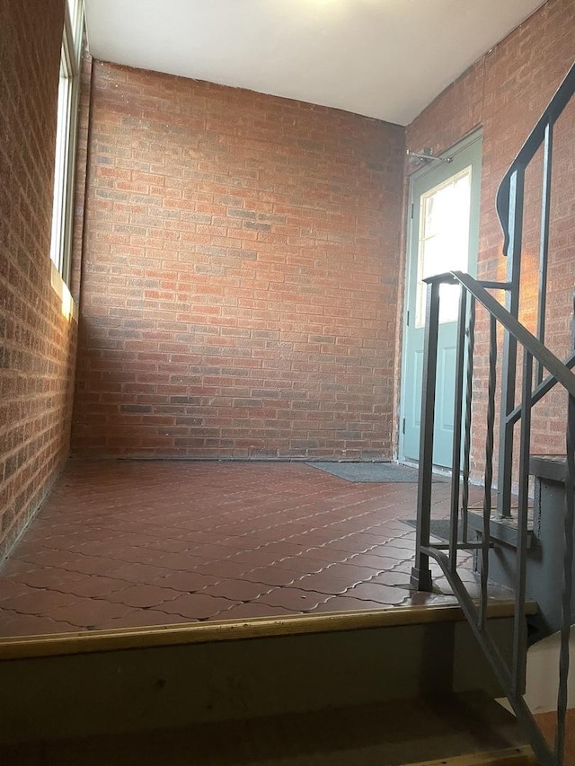 stairway featuring brick wall