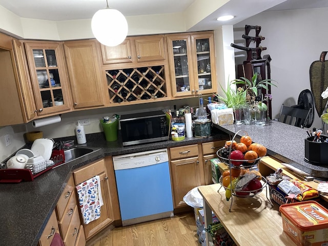 kitchen with dishwashing machine, stainless steel microwave, light wood-style floors, and brown cabinets