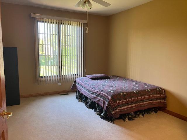 bedroom with visible vents, carpet, baseboards, and ceiling fan