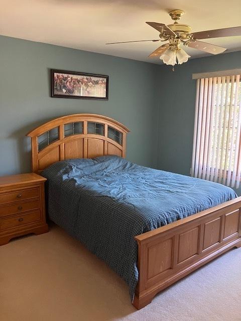 bedroom featuring light carpet and ceiling fan