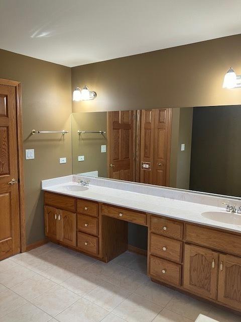 full bathroom featuring double vanity, tile patterned floors, and a sink