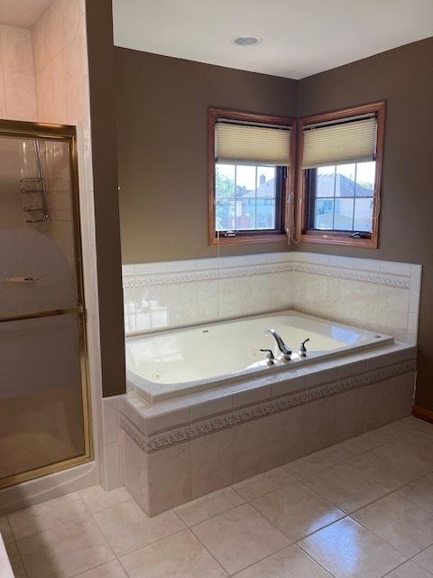 full bathroom with tile patterned flooring, a stall shower, and a bath