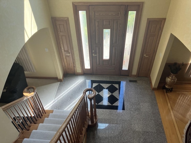 foyer entrance with granite finish floor, visible vents, and baseboards