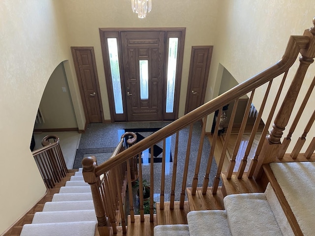 foyer with an inviting chandelier, stairway, and wood finished floors