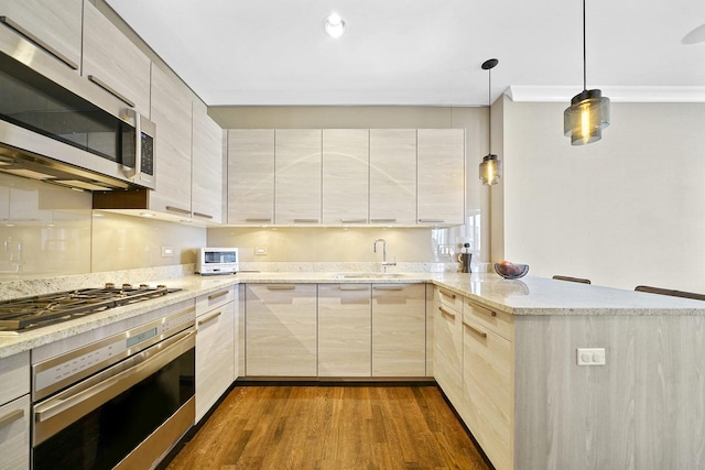 kitchen with modern cabinets, dark wood-type flooring, appliances with stainless steel finishes, and a peninsula