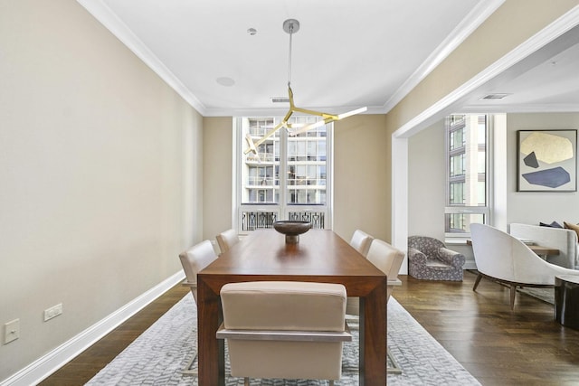 dining area featuring dark wood-style flooring, a wealth of natural light, and ornamental molding