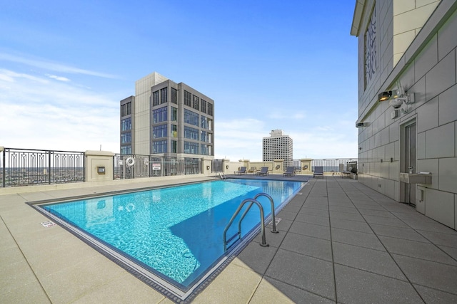 community pool with a patio and fence