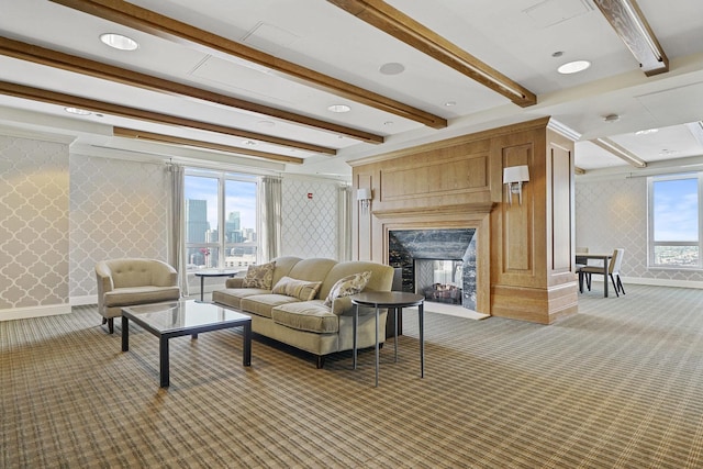 living room featuring beam ceiling, carpet floors, a fireplace, wallpapered walls, and baseboards