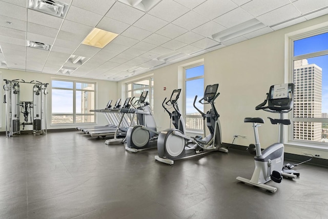 exercise room featuring baseboards, visible vents, and a drop ceiling