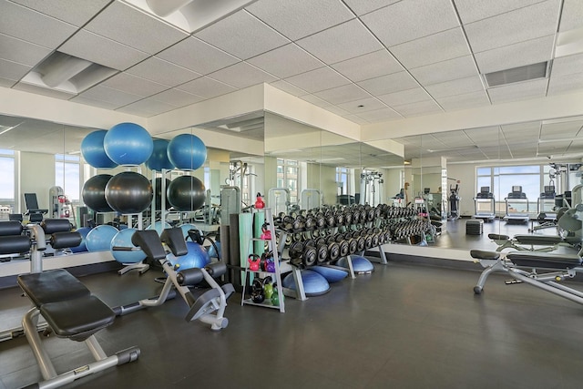 exercise room with visible vents and a paneled ceiling