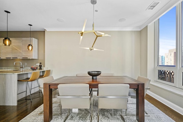 dining space with visible vents, dark wood-style floors, baseboards, and ornamental molding